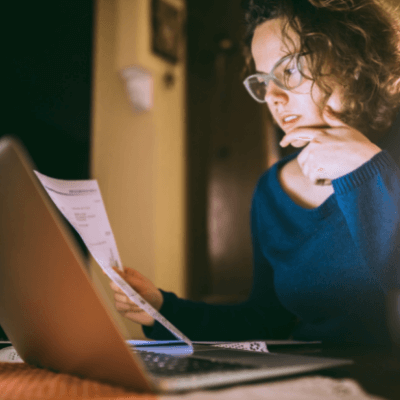 Young woman reviewing bills, looking worried
